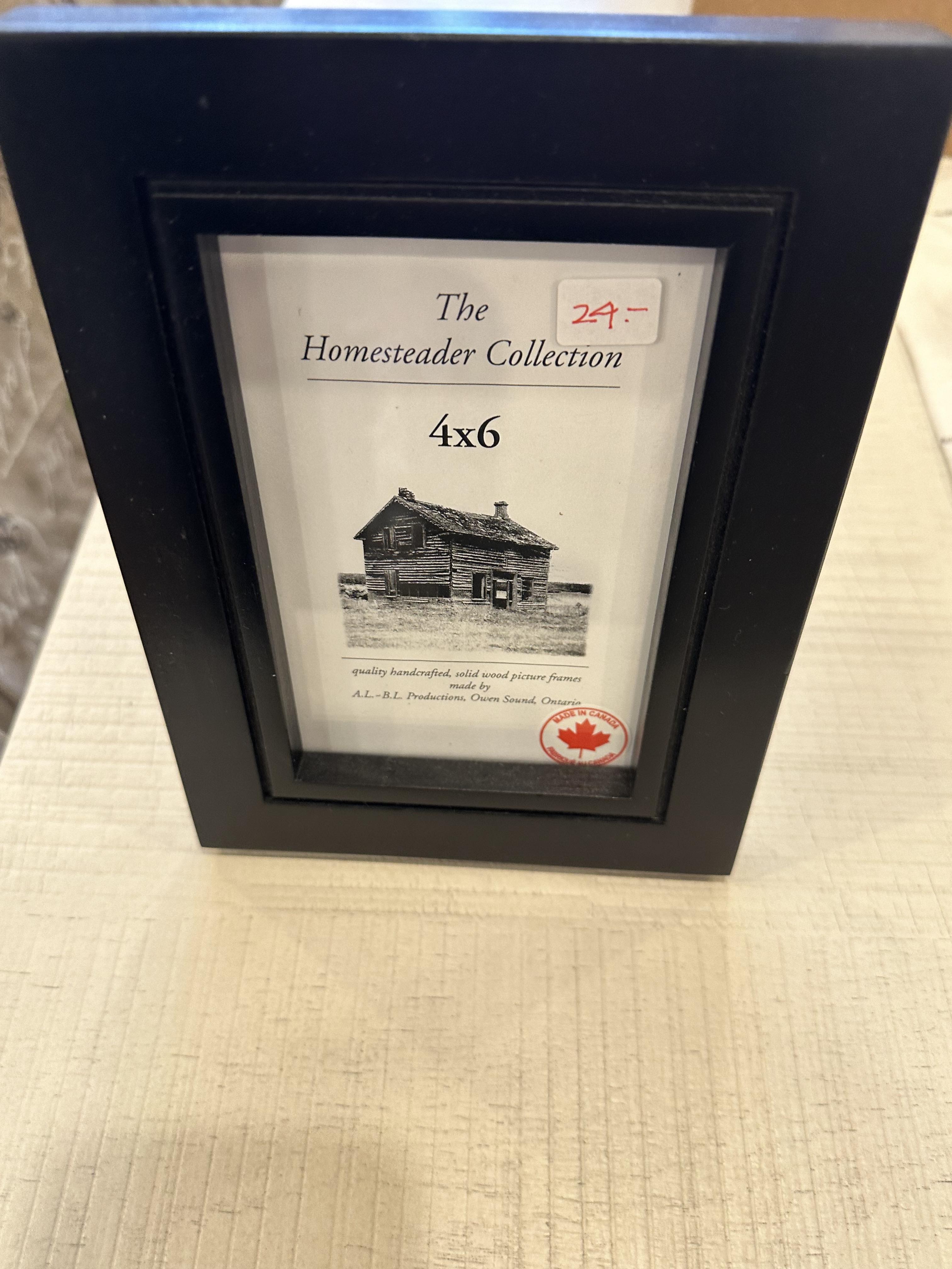 A 4x6 black picture frame with a clear glass panel, displaying a label for 'The Homesteader Collection' with a price tag.