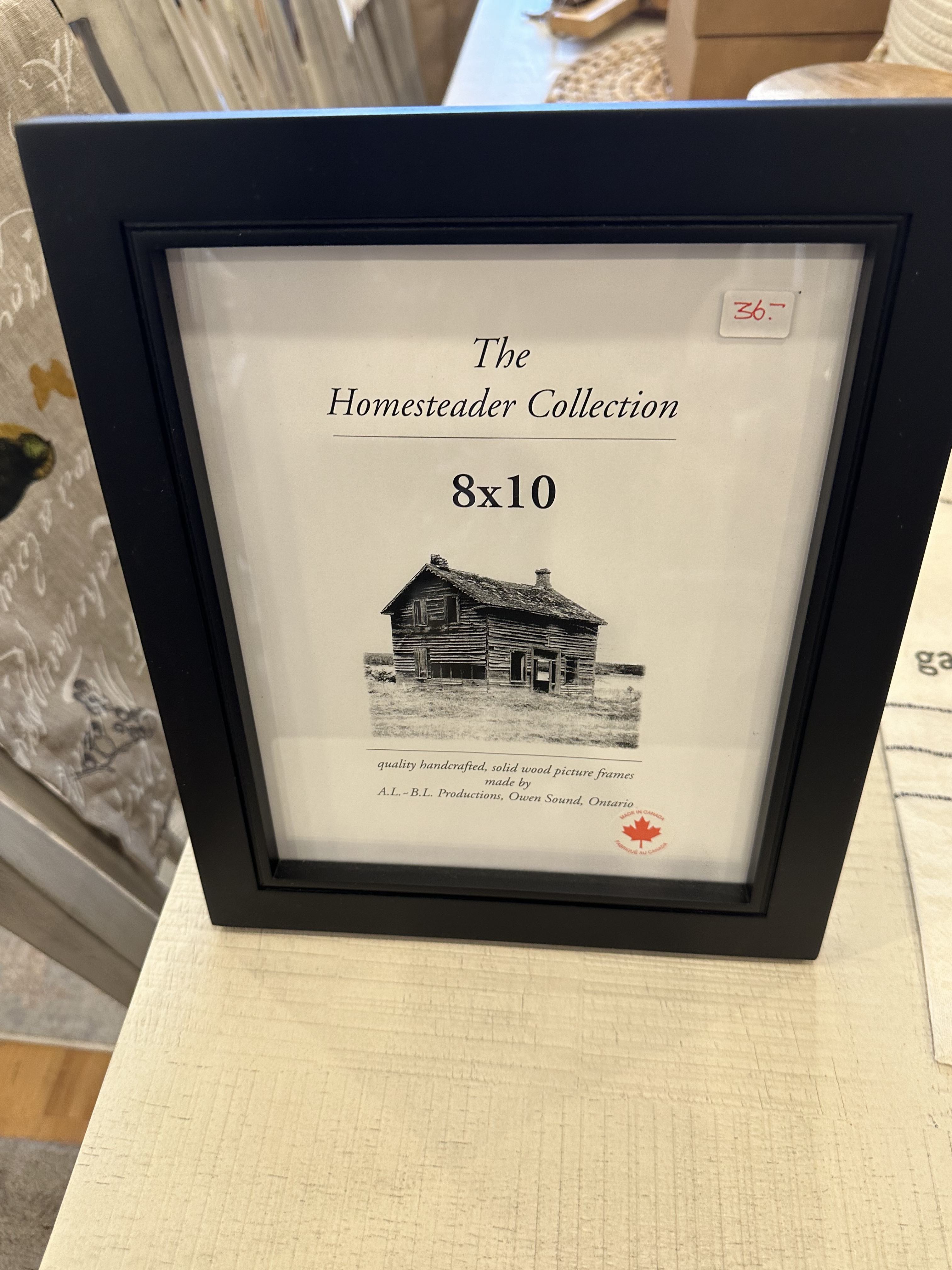 An 8 x 10 black picture frame with a label that reads 'The Homestead Collection' and '8x10'.