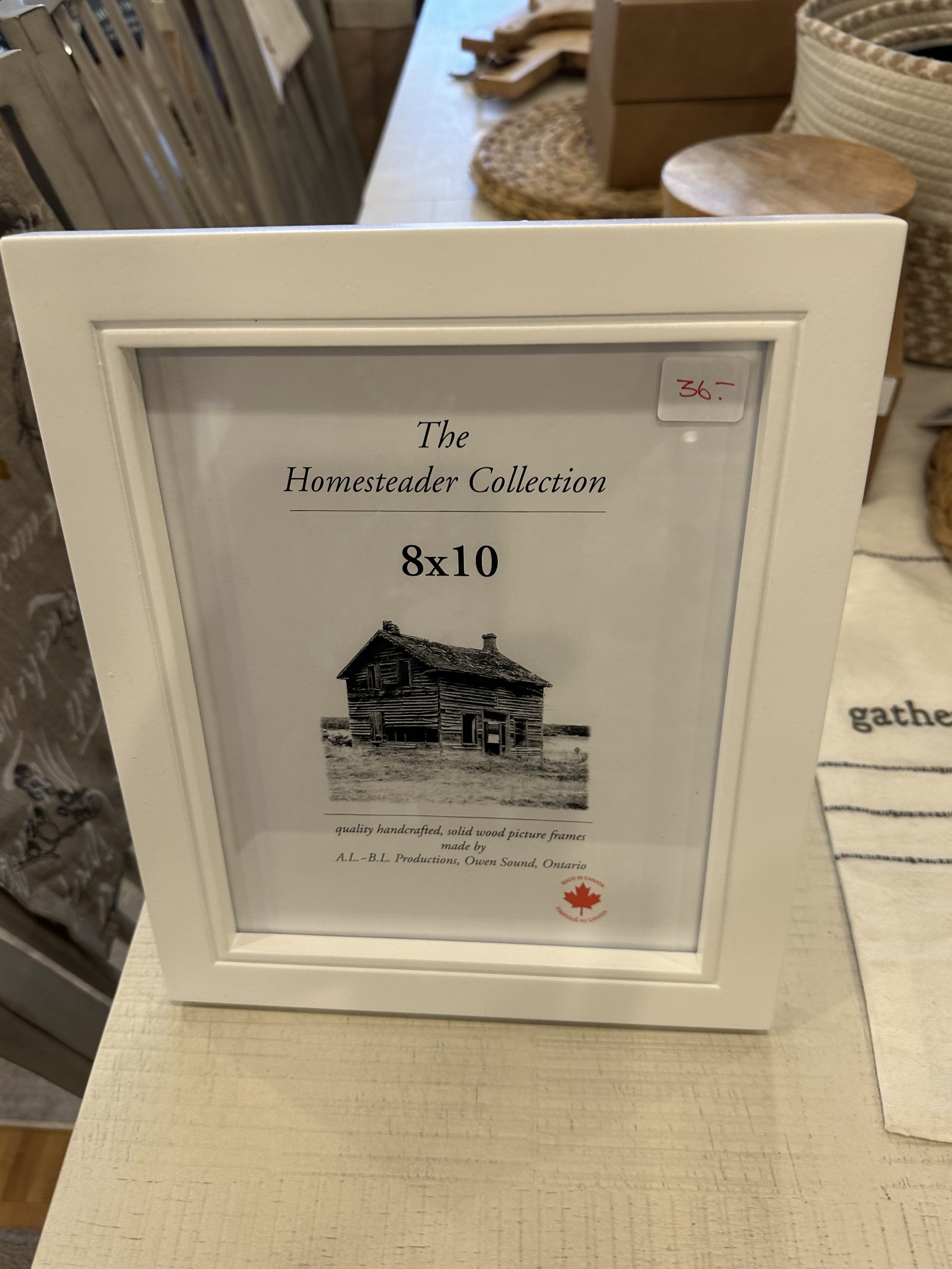 White wooden 8x10 picture frame with glass window and a "The Homesteader Collection" Label