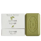 White package of Belle De Provence Olive & Mint hand soap beside a green bar of soap on a white background. 