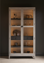 Light wash wooden cabinet with glass doors, 4 interior shelves and one drawer. 