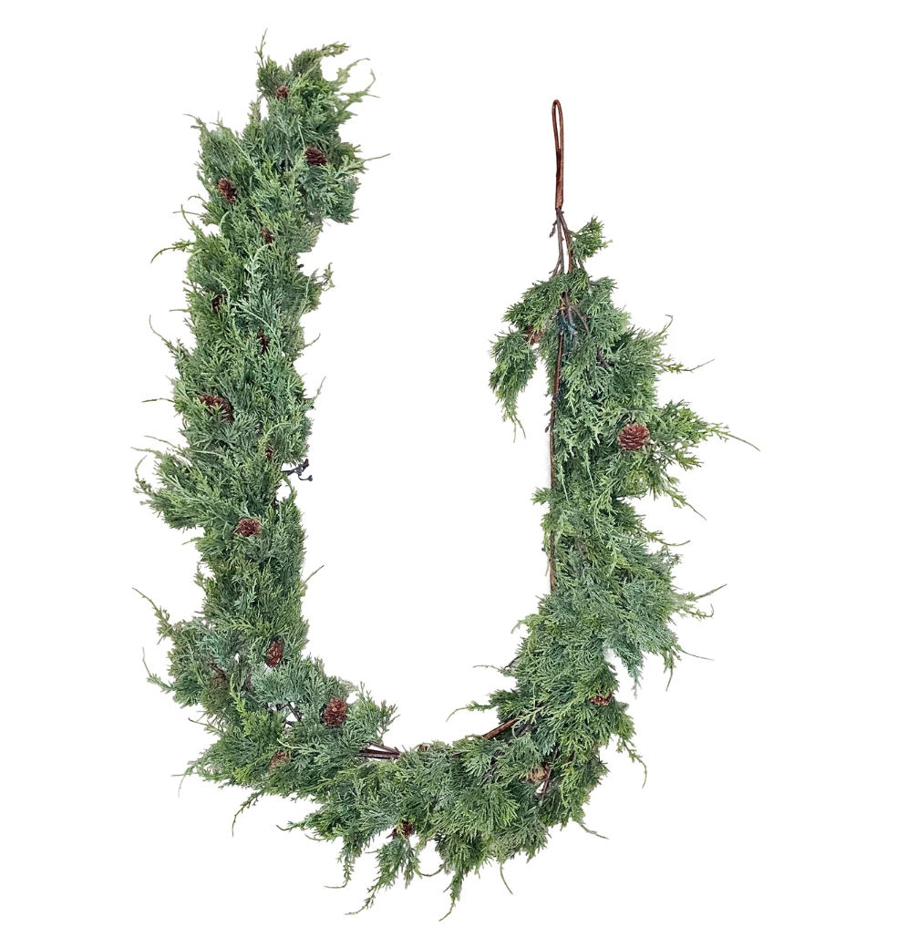 Decorative faux cedar garland on a white background