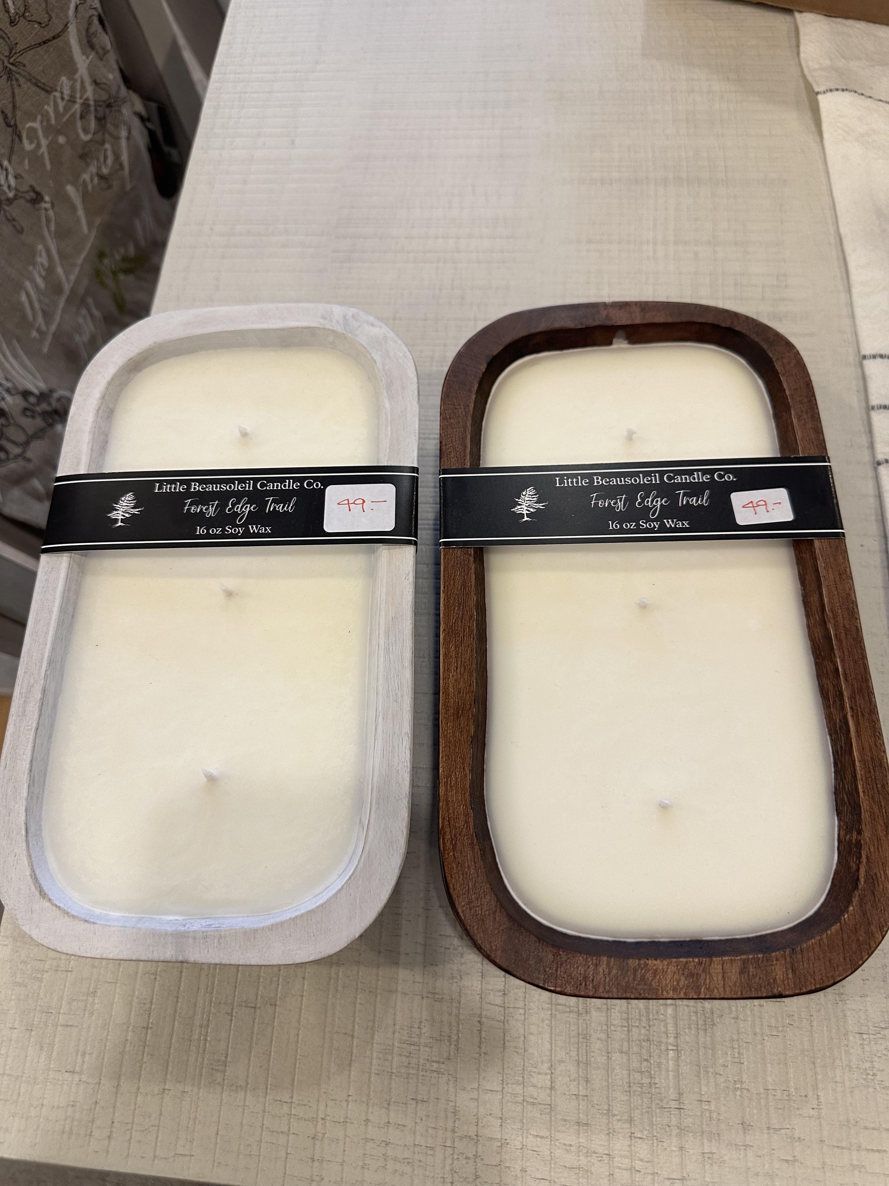 Two candle holders, one with a clear cover and the other with a wooden lid, both with a trail edge design.