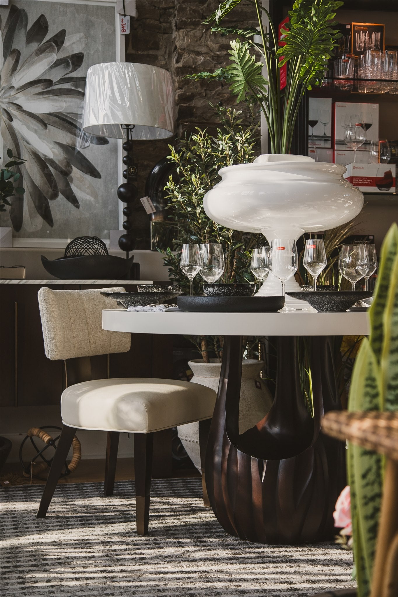 Dining room with a table set for a meal, chairs, and decorative elements.