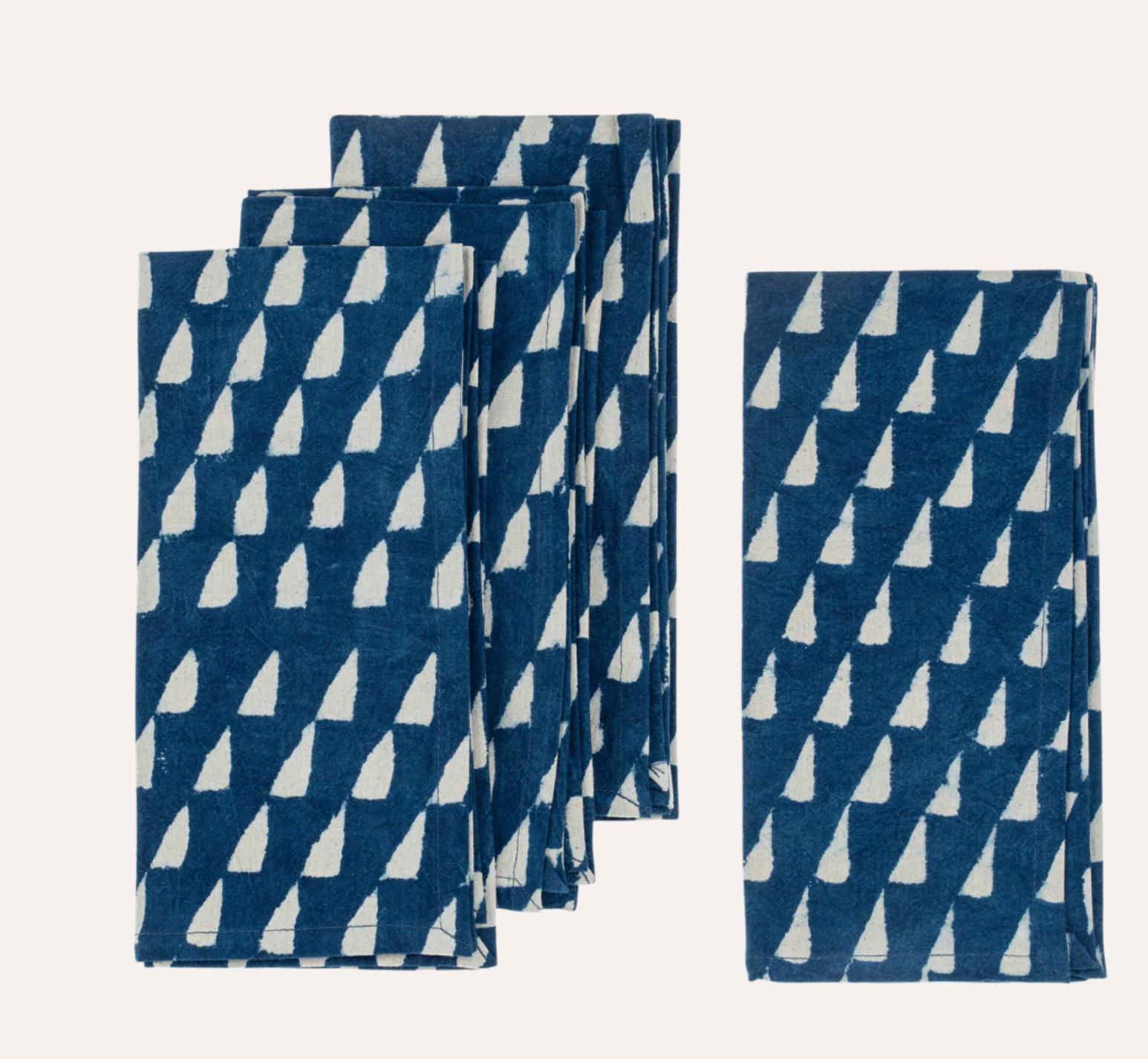 Set of folded blue and white patterned towels on a white background