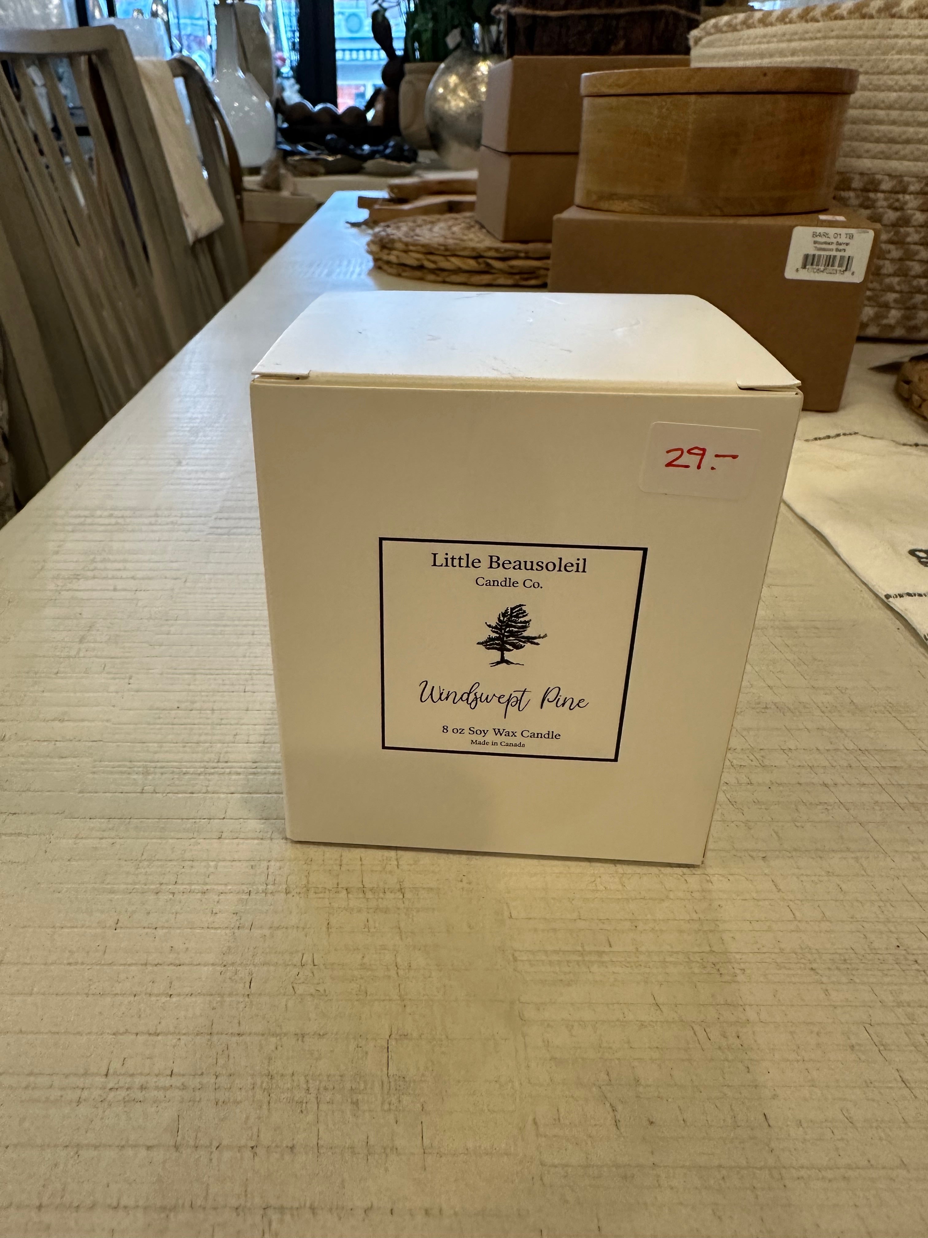 A white box with a Little Beausoleil Candle Co label with an 8oz candle in the scent Windswept Pine. 