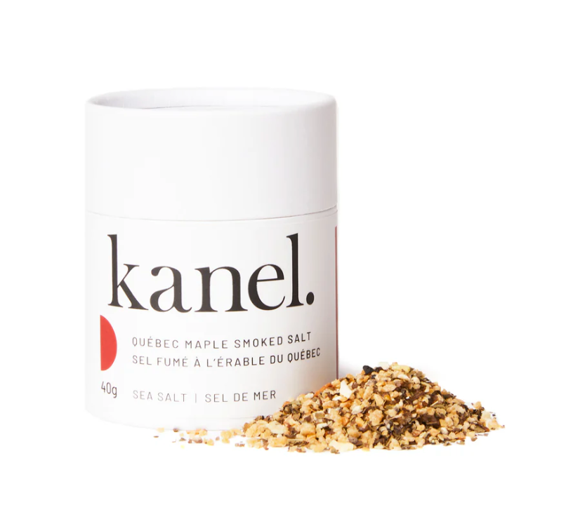 White cylindrical package of Kanel Quebec Maple Smoked Salt on a white background with a small pile of spices. 