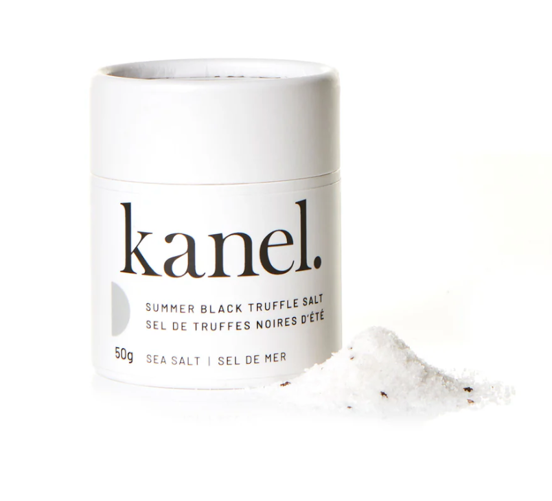 White cylindrical package of Kanel's Summer Black Truffle Salt on a white background with a small pile of salt. 