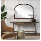 Wooden console table with mirror, lamp, and decor items in a room setting.