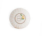 A round soap wrapped in white paper with a label that reads "belle De Provence Citron" with an image of lemons on a branch. 