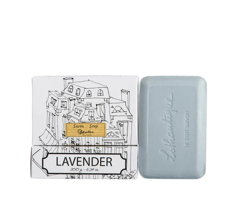 A white box of Lothantique bar soap with a drawing of a cityscape and labelled with the scent Lavender, beside a light blue bar of soap. 
