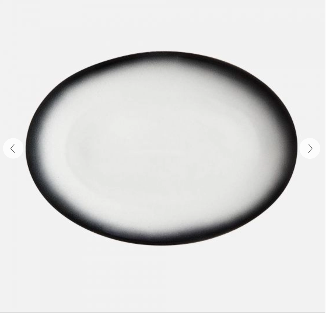 An oval-shaped, black and white porcelain platter with a smooth finish.