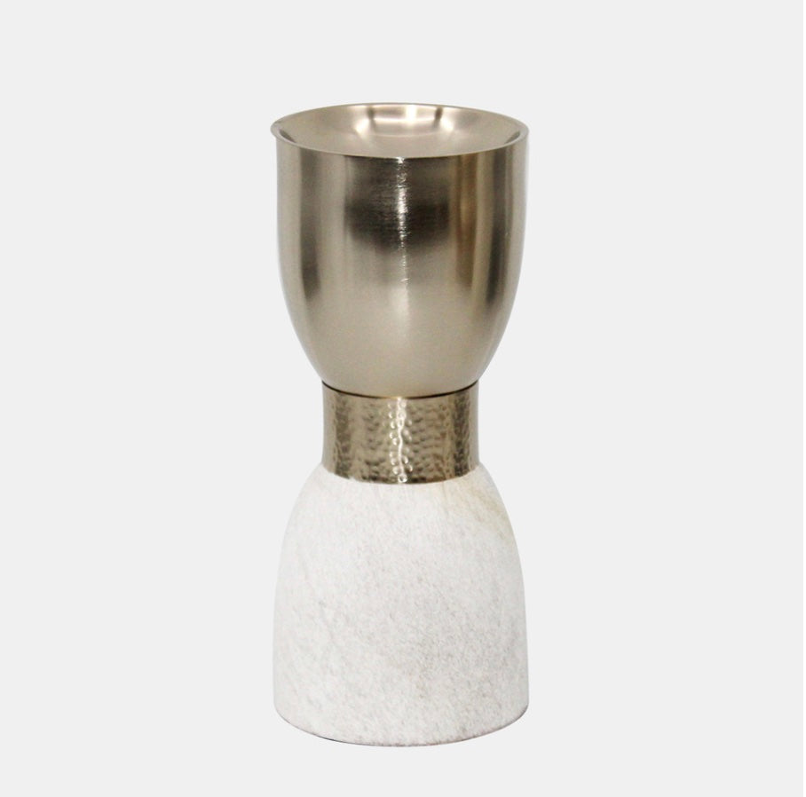 A metal candleholder with a gold upper part atop a white stone-like base.