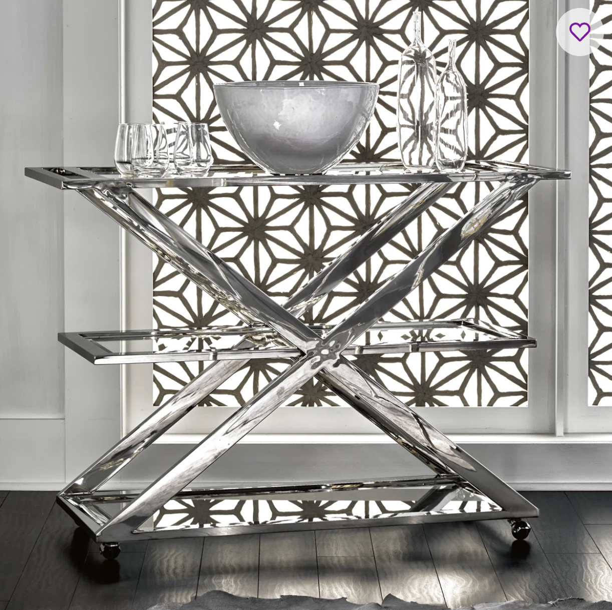 Modern stainless steel bar cart with geometric design in a room with decorative wall patterns.