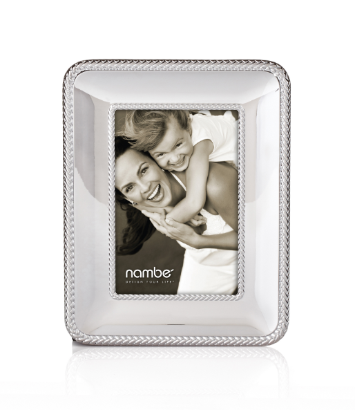 A silver picture frame with braid detail around the outer edge, designed by Sean O’Hara. The frame contains a 4" x 6" photo of two smiling individuals embracing.