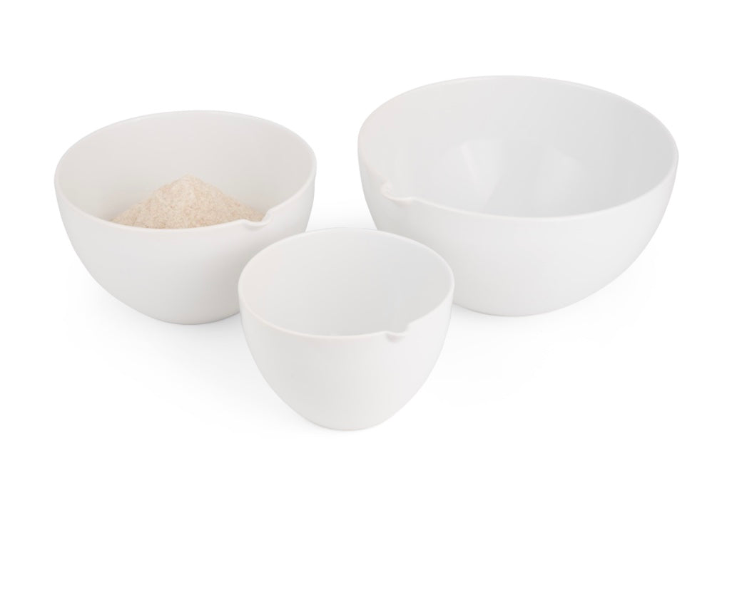 Three white nesting stoneware mixing bowls on a white background. 