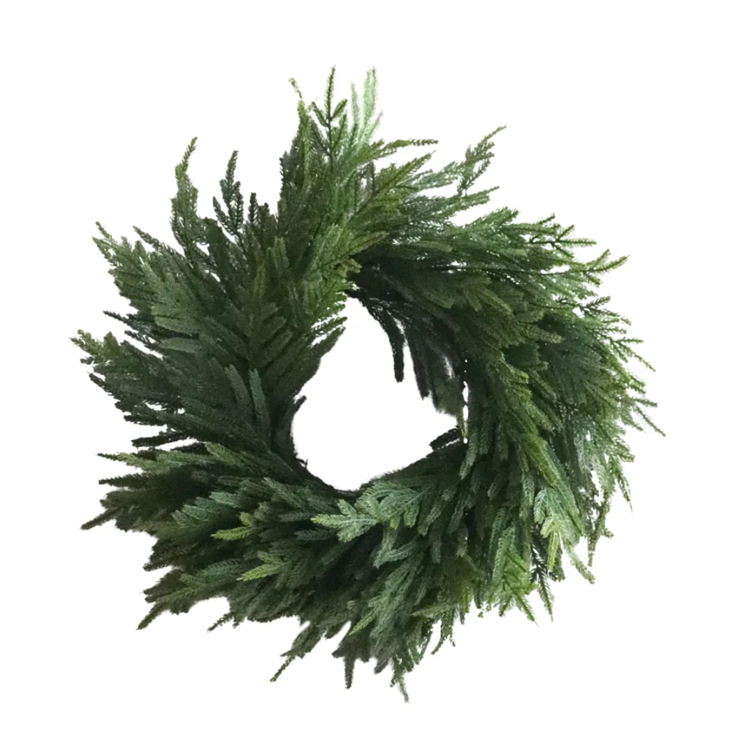 Green artificial Norfolk Pine wreath on a white background