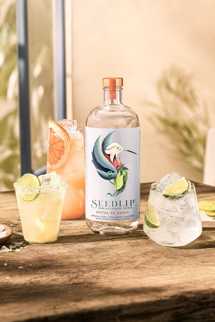Seedlip Notas de Agave bottle with cocktails on a wooden surface