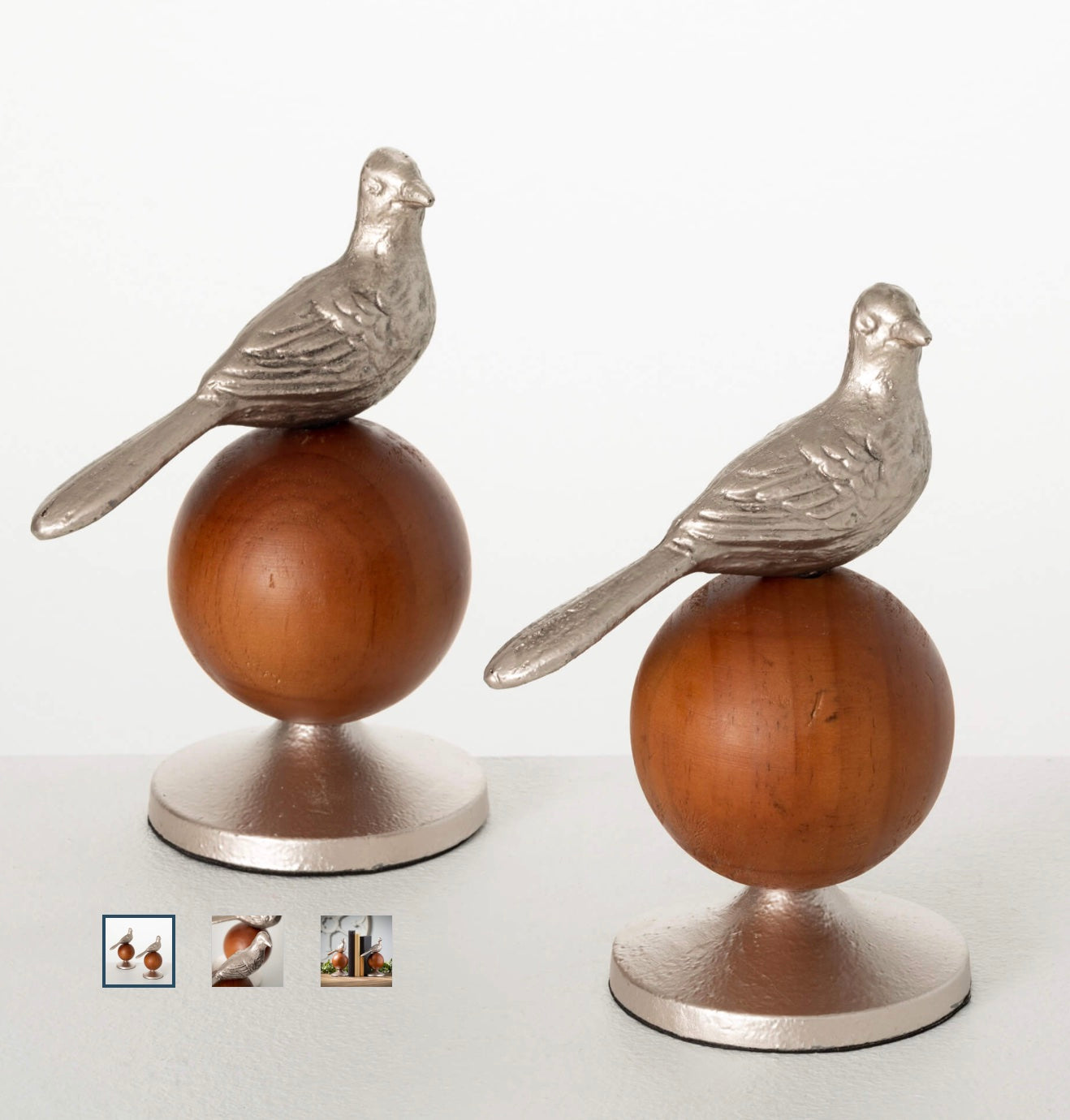 Decorative metallic bird perched on a wooden ball.