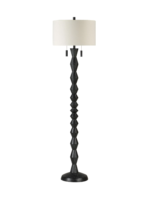 A floor lamp with a geometric-inspired black body and a cream linen drum shade, with pull chains for turning it on and off.