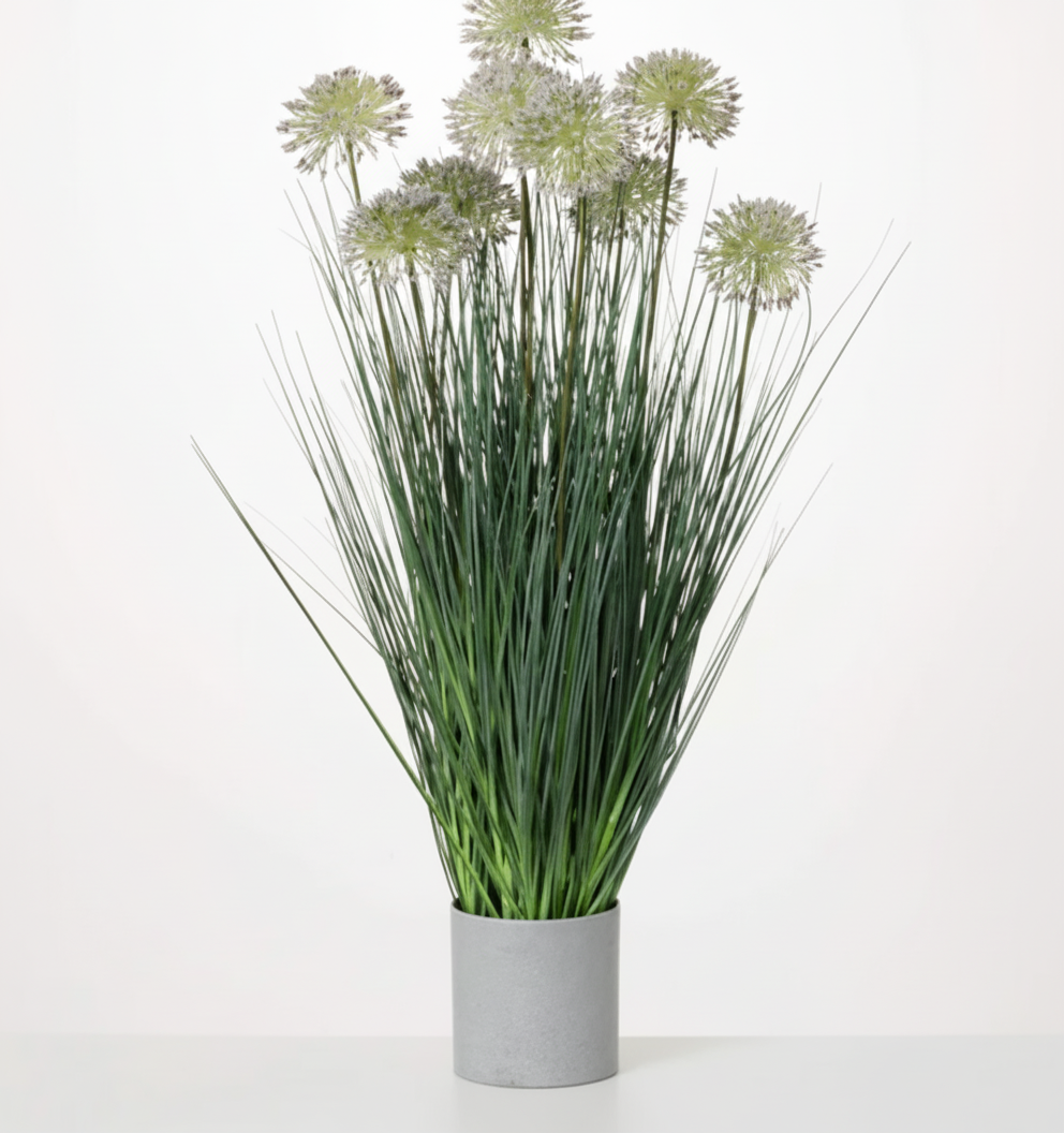 A potted artificial puff grass plant with green blades and gray flowers, placed in a gray cylindrical vase.