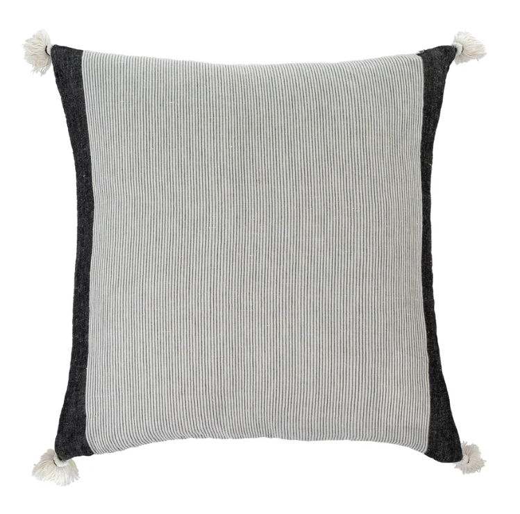 A square-shaped cushion with a striped pattern in shades of gray and black, featuring tassels on the corners.