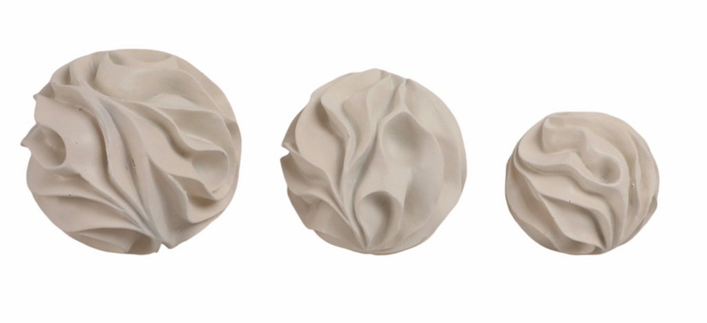 Three beige decorative balls on a white background