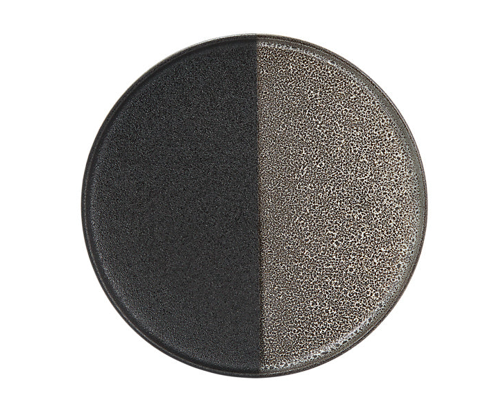 A round porcelain plate with a high rim, featuring a two-tone reactive glaze with a textured surface.