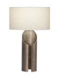 A modern art inspired table lamp with an  organic silhouette base, with a warm antique brass finish. Beige lamp shade.