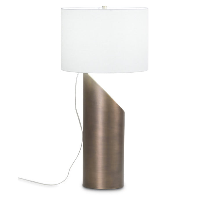Profile view of a modern art inspired table lamp with an  organic silhouette base, with a warm antique brass finish. Beige lamp shade.