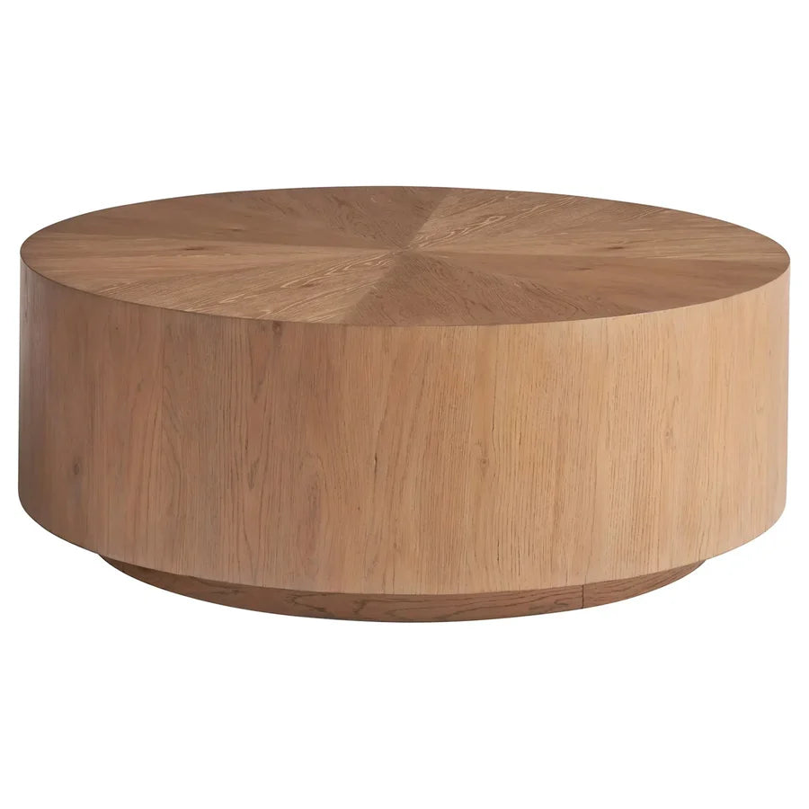 A round, wood cocktail table with a knotty oak finish and visible wood grain, supported by a cylindrical base and equipped with casters.