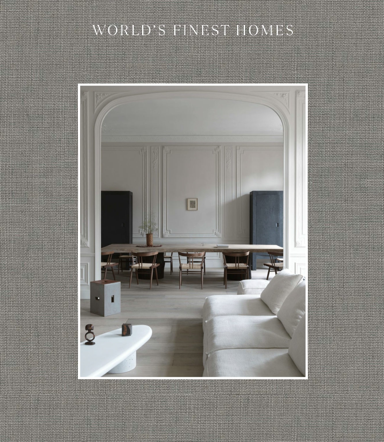 Cover of the book 'World's Fines Homes' displaying a lavish interior shot of a modern living room with a linen-like fabric.